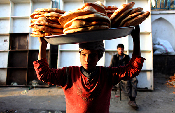 A boy selling bread during Ramadan. During this month, Afghan Muslims fast during the day and celebrate in the evening by eating dinner with families and friends. Kabul, 2011. 