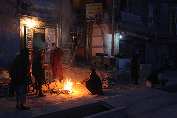 Passengers keep warm as they wait for an early morning bus to the northern city of Mazar-e-Sharif. Kabul, 2011. 